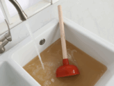 A clogged drain has backed up a sink with dirty water