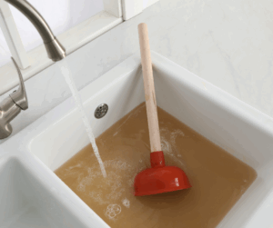 A clogged drain has backed up a sink with dirty water